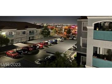 Night view of well lit parking lot with covered parking at residential building near city lights at 6955 Durango Dr # 3092, Las Vegas, NV 89149