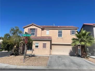 Two story home with a two car garage, desert landscaping, and a red tile roof on a clear day at 8089 Windmill Villa St, Las Vegas, NV 89139