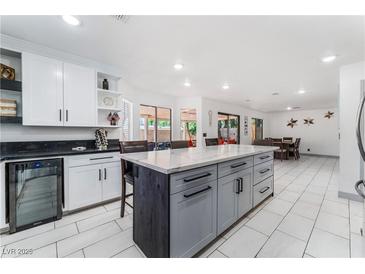 Modern kitchen with a central island, white cabinets, and stainless steel wine cooler at 9005 Feather River Ct, Las Vegas, NV 89117