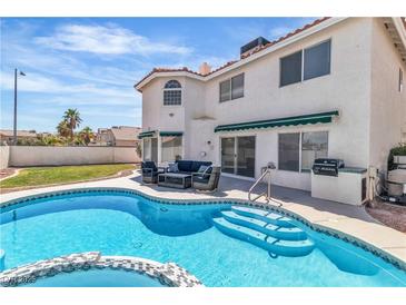 Backyard view of a pool, spa, outdoor kitchen and patio seating at 3604 N Campbell Rd, Las Vegas, NV 89129