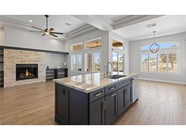 Bright and spacious kitchen features an island, stone fireplace, and stainless steel appliances at 10537 Shoalhaven Dr, Las Vegas, NV 89134