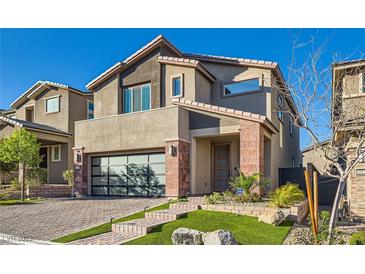 Beautiful two-story home featuring a modern design, a stylish garage door, and manicured landscaping at 10936 White Alder Pl, Las Vegas, NV 89138