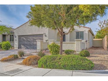 Charming single-story home featuring stucco walls, a tile roof, and a well-maintained front yard with mature landscaping at 130 Mountain Cedar Ct, North Las Vegas, NV 89031