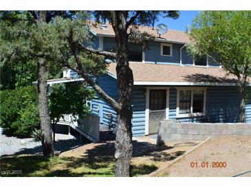 Charming two-story blue home featuring a well-maintained yard and front door at 1382 N Trout Canyon Rd, Las Vegas, NV 89124