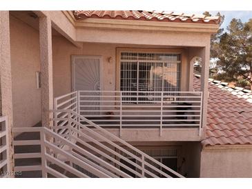 View of front door with landing & railing plus the tile roof above and partial exterior wall at 1900 N Torrey Pines Dr # 225, Las Vegas, NV 89108
