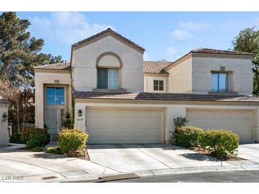 Charming stucco home featuring a tile roof, two-car garage, and manicured landscaping at 2632 Starfish Ct, Las Vegas, NV 89128