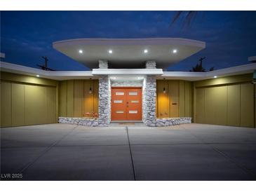 Striking mid-century modern home with an orange door, stone accents, and unique architectural details at 3586 Spencer St, Las Vegas, NV 89169