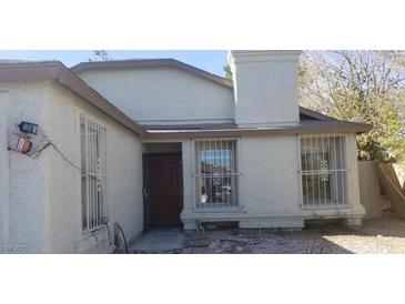 Charming single-story home with a chimney and protective window bars at 3711 Southern Light Dr, Las Vegas, NV 89115