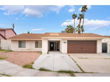 Charming single-story home featuring a two-car garage, desert landscaping, and palm trees at 3994 Ridgewood Ave, Las Vegas, NV 89120