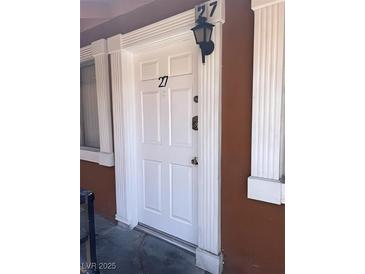 Exterior front door with decorative molding and address number 27, along with a lantern above at 500 S 13Th St # C27, Las Vegas, NV 89101