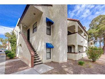 A multi-level exterior view of a condominium with stucco walls and a tiled roof, set against a bright sky at 6109 W Oakey Blvd # C, Las Vegas, NV 89146