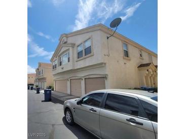 Two-story townhome featuring stucco exterior, two-car garage, and satellite dish on facade at 6425 Extreme Shear Ave # 101, Henderson, NV 89011