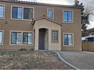 Two story tan home with stucco, many windows and a covered front porch at 2011 Sue Ct # 203, Las Vegas, NV 89108