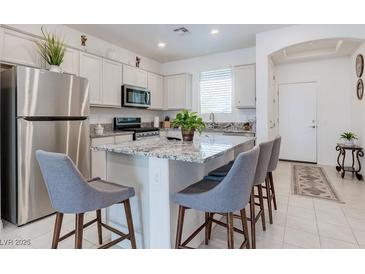 Bright kitchen with stainless steel appliances, granite countertops, and a center island with bar stool seating at 2114 Cold Canyon Ave, North Las Vegas, NV 89086