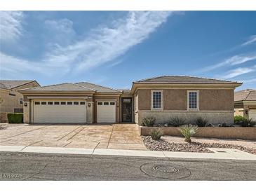 Attractive single-story home with a three-car garage, desert landscaping, and a tile roof under a blue sky at 2743 Evergreen Oaks Dr, Henderson, NV 89052