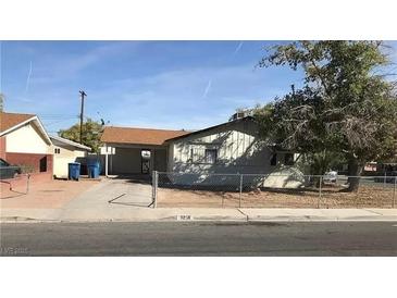 A single-story home with a driveway, carport, desert landscaping, and chain-link fence at 3258 Glenhurst Dr, Las Vegas, NV 89121