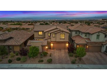 Stunning two-story home with a brick-accented facade, lush landscaping, and a brick driveway at 342 Molinetto St, Las Vegas, NV 89138
