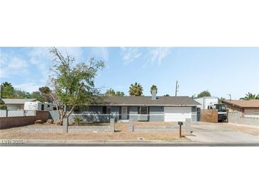 Charming single-story home featuring a gray exterior, a well-maintained yard, and an attached two-car garage at 4870 E Colorado Ave, Las Vegas, NV 89104