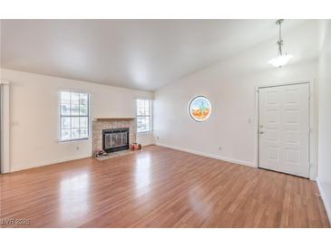 Bright living room with fireplace, hardwood floors, and natural light from two windows at 5068 Jeffreys St # 202, Las Vegas, NV 89119