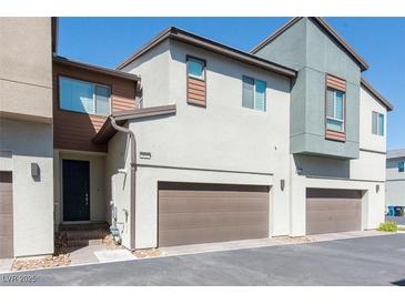 Modern townhome exterior with private garage and neutral color scheme on a sunny day at 6145 May River St, Las Vegas, NV 89148