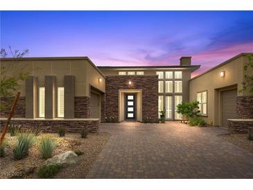 Stunning home featuring a modern elevation, a stone facade, with desert landscaping at 6700 Regency Stone Way, Las Vegas, NV 89148