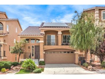 Two-story home featuring a tile roof, balcony, two car garage and meticulously manicured lawn at 6843 Philharmonic Ave, Las Vegas, NV 89139