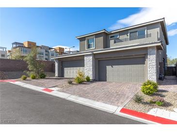 Modern townhome featuring a two-car garage and stone accents in a well-maintained community at 11756 Emerald Lake Ave, Las Vegas, NV 89138