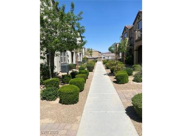 Charming exterior view with landscaped walkway leading to townhomes and mature trees at 1197 Mission View Ct, Henderson, NV 89002