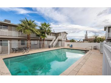 A community pool with lounge chairs is surrounded by palm trees and apartments at 204 Orland St # 2, Las Vegas, NV 89107