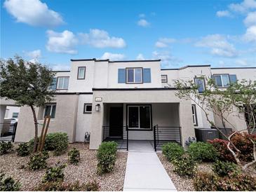 Modern townhome featuring a stucco facade, black trim, and desert landscaping at 3610 Tripoli Cove Ave, Las Vegas, NV 89106