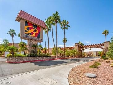 Community entrance showcasing the 'Bella Vita' sign with palm trees and a well maintained landscape at 5339 Indian River Dr # 281, Las Vegas, NV 89103