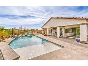 Beautiful pool with a tanning ledge, rock waterfall feature, and covered patio for backyard entertaining at 5755 E La Campana Dr, Pahrump, NV 89061