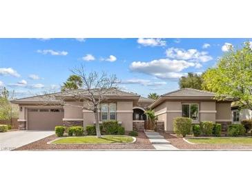 Inviting single-story home with a stone-accented facade, manicured landscaping, and a spacious three-car garage at 6895 Kelp Ledge Ct, Las Vegas, NV 89131