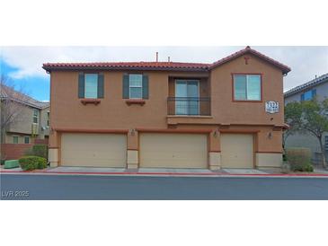 Two-story condo featuring a three-car garage and red tile roof at 7322 Fools Gold St # 102, Las Vegas, NV 89149