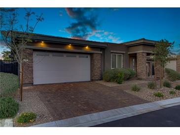 Charming single-story home featuring stone accents, a two-car garage, and desert landscaping at 8 Reflection Cove Dr, Henderson, NV 89011