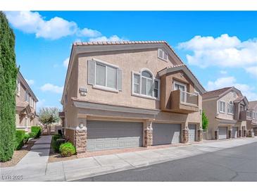 Charming two-story home with attached two-car garage, balcony and landscaped front yard at 8658 Tom Noon Ave # 103, Las Vegas, NV 89178