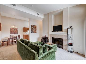 Inviting living room with a fireplace and open floor plan to dining and kitchen at 8985 S Durango Dr # 2014, Las Vegas, NV 89113