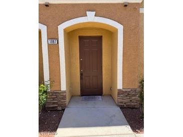 Inviting front door with a charming arched entrance and stylish stacked stone accents at 9303 Gilcrease Ave # 1097, Las Vegas, NV 89149