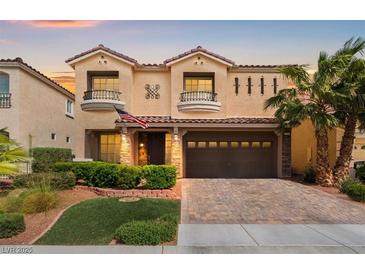 Beautiful two-story home features a paver driveway, manicured landscaping, and a spacious two car garage at 9768 Fox Estate St, Las Vegas, NV 89141