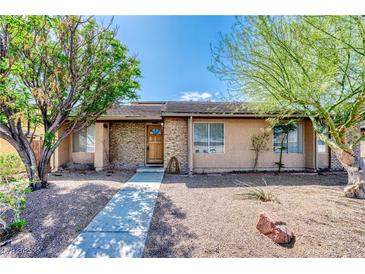 Charming single-story home featuring a well-maintained yard with mature trees and a brick accent wall at 1501 Living Desert Dr # A, Las Vegas, NV 89119