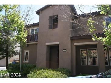 Charming two-story townhouse featuring stucco siding, balcony and landscaped front yard at 1837 Ardilea St, Las Vegas, NV 89135