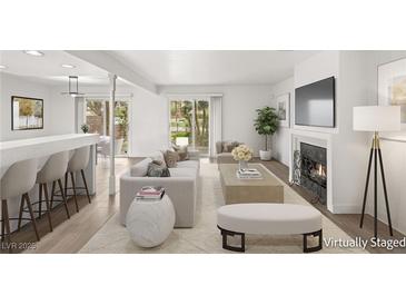 Bright living room with modern furniture, fireplace, and sliding glass doors to the outdoor area at 2935 Pinehurst Dr, Las Vegas, NV 89109