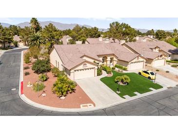 Aerial view of a well-maintained home featuring a pristine lawn, desert landscaping, and a two car garage at 5612 Beach Mill Way, Las Vegas, NV 89130