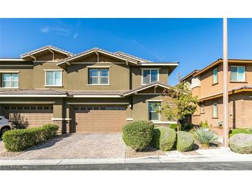 Attractive two-story home with a paved driveway, two-car garage and manicured front yard landscaping at 5697 Garriga Dr, Las Vegas, NV 89135
