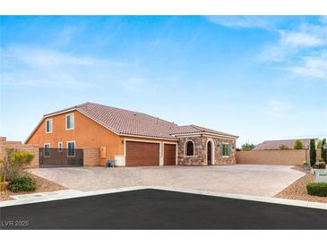 A charming single-story home boasts a three car garage, desert landscaping and a beautiful mediterranean facade at 9096 Becket Ranch Ct, Las Vegas, NV 89113