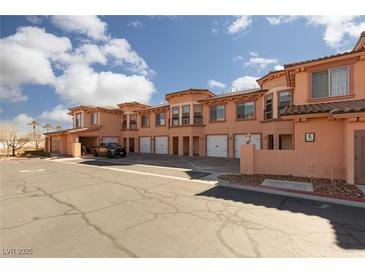 Charming townhome with multiple units, white garage doors and beautiful desert landscaping at 6 Via Vasari # 105, Henderson, NV 89011