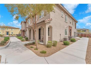 Charming townhome with arched entryway, desert landscaping, and a well-maintained walkway to the front door at 8507 Insignia Ave # 102, Las Vegas, NV 89178