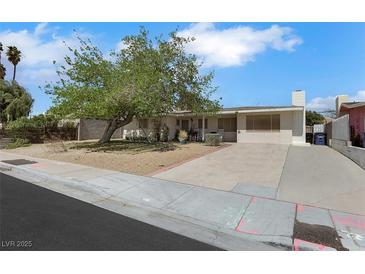 Charming single-story home featuring a spacious front yard and a long private driveway at 1041 E Saint Louis Ave, Las Vegas, NV 89104