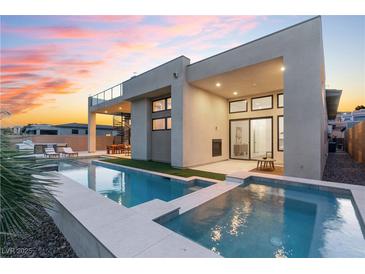 Stunning modern home showcasing a luxurious pool with integrated spa and a spacious outdoor living area at dusk at 144 Tre Pietre St, Henderson, NV 89011