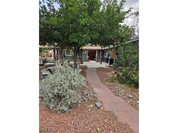 Charming home with lush greenery and a welcoming pathway to the entrance at 1812 Ivanhoe Way, Las Vegas, NV 89102